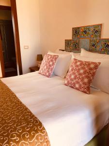a bedroom with a bed with white sheets and pillows at Appartamento Senia in San Vito lo Capo