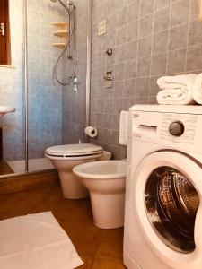 a bathroom with a washing machine and a toilet at Appartamento Senia in San Vito lo Capo
