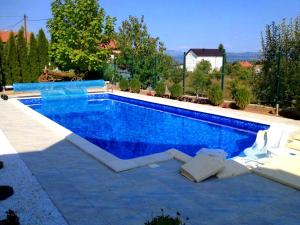 a swimming pool with blue water in a yard at Villa Elma in Sarajevo