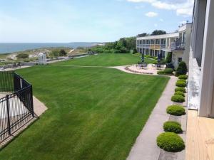 a view from the balcony of a building with a green lawn at Surf & Sand Beach Motel in South Yarmouth