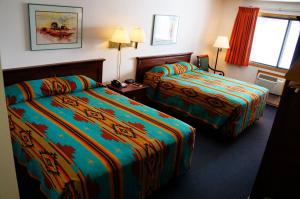 a hotel room with two beds with colorful sheets at Fort Randall Casino & Hotel in Pickstown