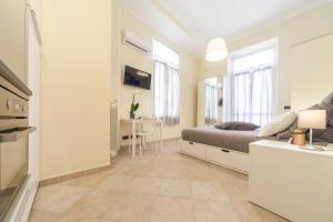 een witte slaapkamer met een bed en een tafel bij Narciso Centralissimo in Sanremo