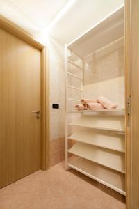a walk in closet with white shelves and a door at Narciso Centralissimo in Sanremo