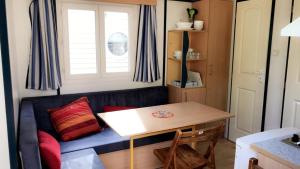 a living room with a blue couch and a table at Camping la Croix du Sud in Saint-Tropez