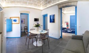 a living room with a table and chairs and a couch at Suite&Maré in Favignana