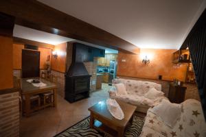 a living room with a couch and a stove at Hostal Rural Los Telares in Pastrana