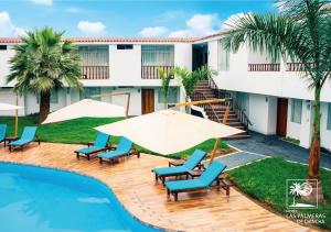 a resort with a pool and chairs and a building at Qallwa Chincha in Chincha Alta