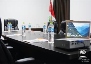 - une table avec un ordinateur portable et des bouteilles d'eau dans l'établissement Qallwa Chincha, à Chincha Alta