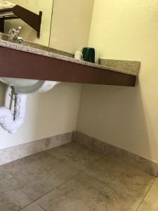 a bathroom with a sink and a mirror at Sunrise Inn - Bradenton in Bradenton