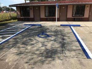 a parking lot with blue lines in front of a building at Sunrise Inn - Bradenton in Bradenton