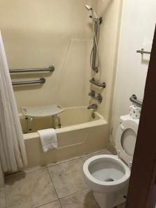 y baño pequeño con aseo y bañera. en Sunrise Inn - Bradenton, en Bradenton