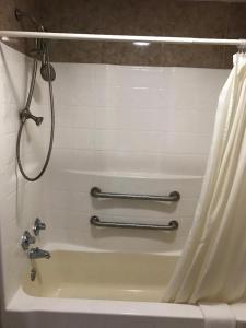 un baño con ducha y bañera en Sunrise Inn - Bradenton, en Bradenton