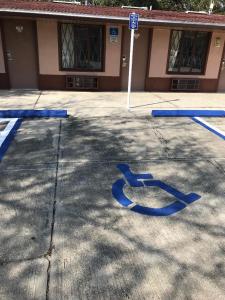 a parking lot with blue handicapped signs in front of a building at Sunrise Inn - Bradenton in Bradenton