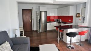 アリカンテにあるSun & Beach Apartment Carivoguestのキッチン、リビングルーム(赤いキャビネット、テーブル付)