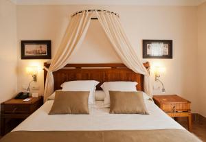a bedroom with a large white bed with a canopy at Princesa Yaiza Suite Hotel Resort in Playa Blanca