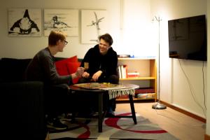 twee mannen die een bordspel spelen in een woonkamer bij Ammarnäs Wärdshus in Ammarnäs