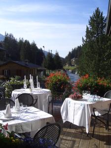 dwa stoły z białymi ścierkami na patio w obiekcie Hotel Baita Fiorita w mieście Santa Caterina Valfurva