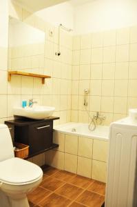 a bathroom with a toilet and a sink and a tub at Garncarska 7 - 2BR by Homeprime in Krakow