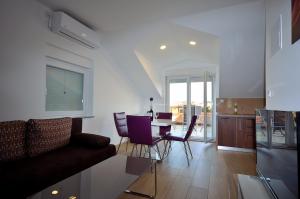 a living room with a couch and a table and chairs at The Nikolic Suites - Villa Wögenstein in Tribunj