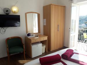 a bedroom with a bed and a dresser and a mirror at Guest House Villa Bellevue in Cavtat