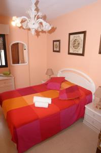 1 dormitorio con 1 cama colorida y toallas. en habitacion centro historico malaga, en Málaga