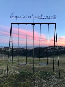 a swing set in a field with the words compare mum and me in need at B&B Cà Bianca dell'Abbadessa in San Lazzaro di Savena