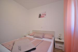 a bedroom with a bed with pink and pink sheets at The Nikolic Suites - Villa Wögenstein in Tribunj