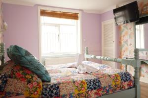 a bedroom with a bed with a quilt on it at Regency Hotel in Brighton & Hove