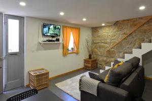 a living room with a couch and a tv at Oporto Memory Houses 7 in Porto