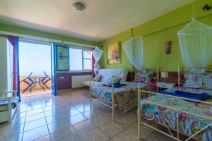 a room with two beds and a table and a balcony at Ocea Retreat in Karlovasi