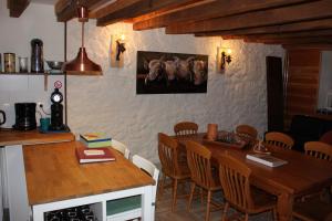 cocina con mesa de madera y comedor en Maison le Barrage, en Saint-Gervais-dʼAuvergne