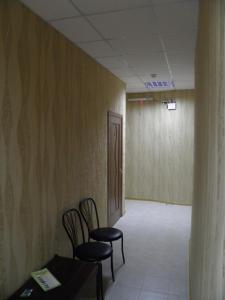a room with two chairs and a table and a door at Atrium Hotel in Melitopol
