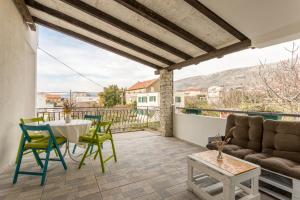 a living room with a table and chairs on a balcony at Apartment More in Kaštela