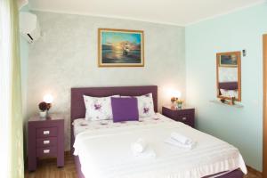 ein Schlafzimmer mit einem Bett und zwei Nachttischen in der Unterkunft Apartments Ivona in Sveti Stefan