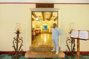 a man standing in the hallway of a building at Hacienda Uxmal Plantation & Museum in Uxmal