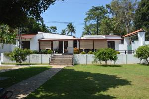 a house with a fence and a yard at Olivi Palace in Udawalawe