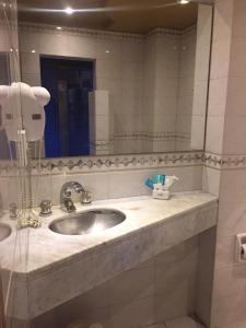 baño con lavabo y espejo grande en Dallas Hotel -Motel- en Buenos Aires