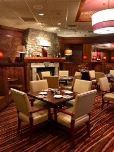 a restaurant with a table and chairs and a fireplace at Best Western Ramkota Hotel in Rapid City