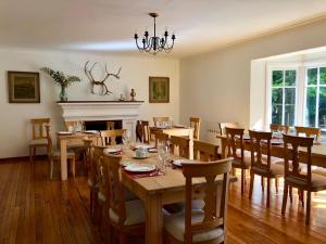 a dining room with tables and chairs and a fireplace at Hostería Pionero in Cerro Castillo