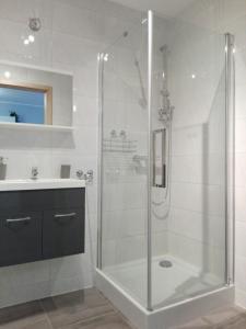 bagno bianco con doccia e lavandino di Apartament Marzenie 6 - Opole a Opole