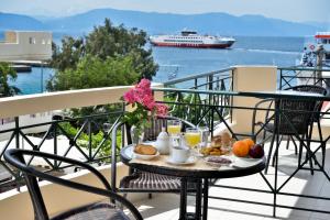 a breakfast table on a balcony with a cruise ship at Evia Studios in Loutra Edipsou
