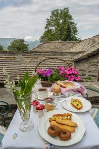 Thoukididis في Kapesovo: طاولة عليها أطباق من الطعام والزهور