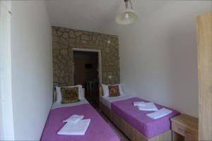 two beds in a room with purple sheets at Apartments Astel in Bar