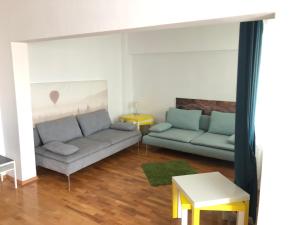 ein Wohnzimmer mit 2 Sofas und einem Tisch in der Unterkunft Green Apartment 3 in Bukarest