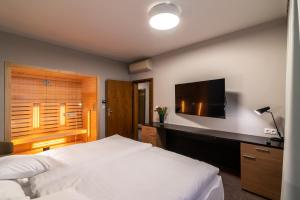 1 dormitorio con 1 cama y TV de pantalla plana en Hotel Karpatia, en Humenné