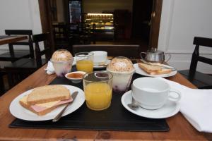 una mesa con una bandeja con bocadillos y tazas de zumo de naranja en Lucia Agustina Hotel Boutique, en Santiago