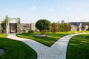 a brick walkway in a park with green grass at Sky Hotel in Oradea