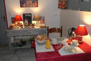 a table with a red table cloth and two lamps at Le Termenès in Félines-Termenès