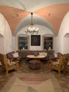 a living room with a chandelier and a table and chairs at Gasthof Gemse in Prutz