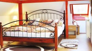 1 dormitorio con 1 cama con marco de madera en Porcelán Vendégház en Hollóháza